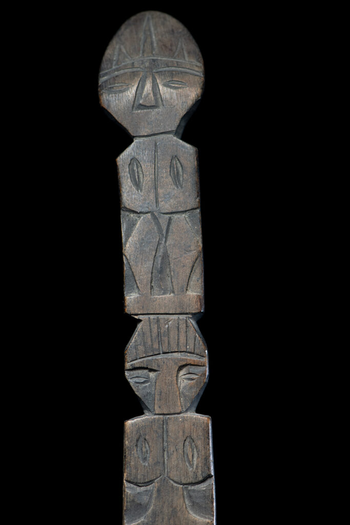 Old wooden spoon from the Paiwan tribe, carved with two full-length standing figures, one above the other.