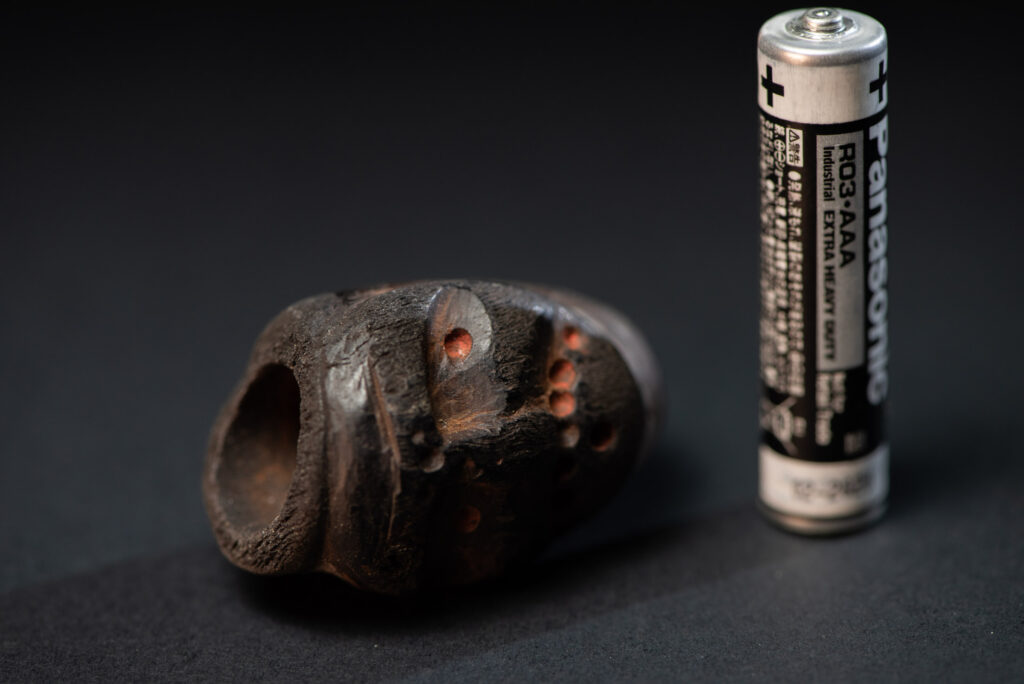 Paiwan tribe pipe bowl carved with a human face.