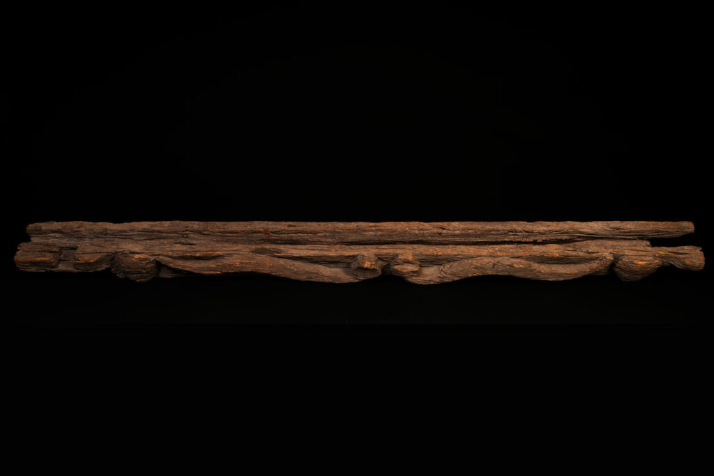 19th-century door lintel from the Paiwan tribe, carved with a pair of snakes facing each other and two human faces on either side. This Paiwan panel is heavily eroded and was probably placed above the entrance, exposed to the elements.