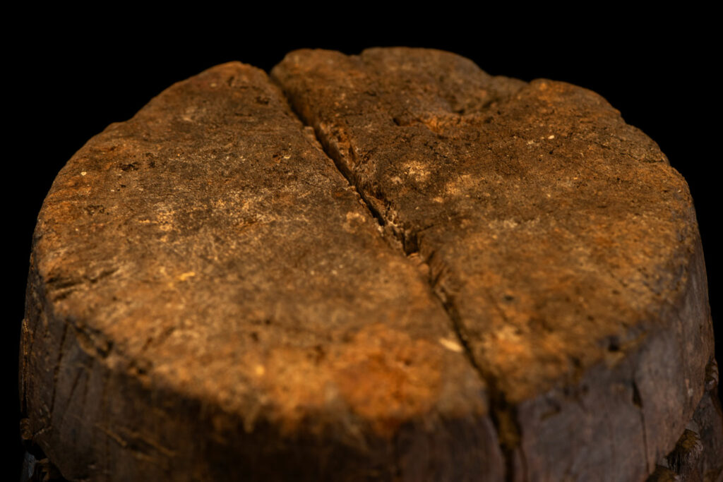 Small ancient mortar from the Paiwan tribe, richly carved around its circumference with a chain of crouching Paiwan figures.