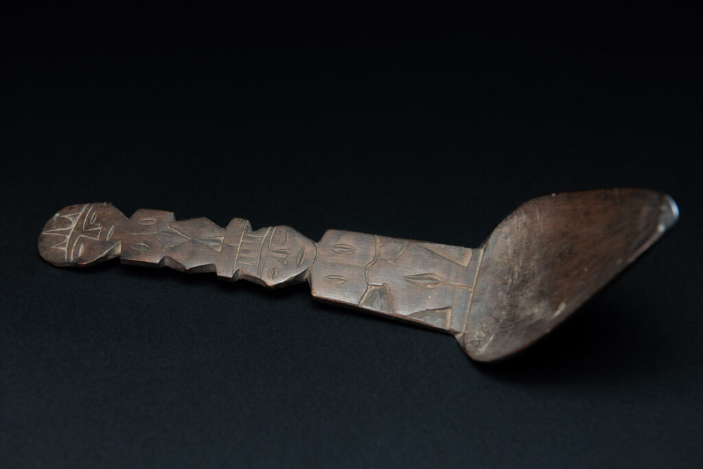 Ancient spoon from the Paiwan tribe, carved with two standing figures, one above the other.