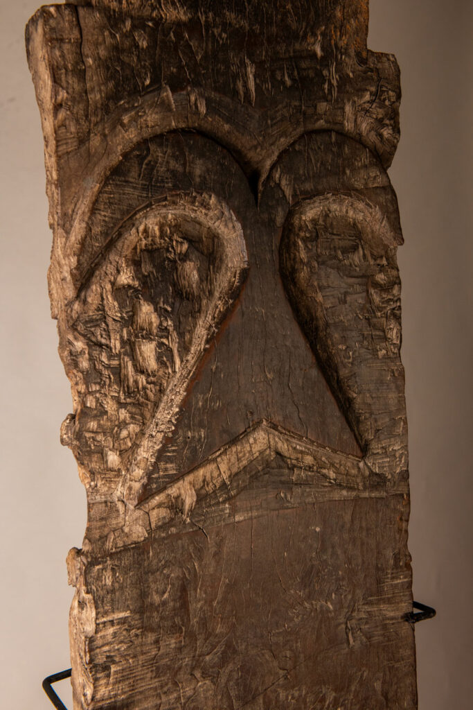 Rare and massive early 19th-century panel from the East Coast Paiwan tribe, carved in the Taimali style. It features a prominent central nose, a stylized face at the top, and another face carved at the bottom — a characteristic design of the Southeastern Paiwan tradition.