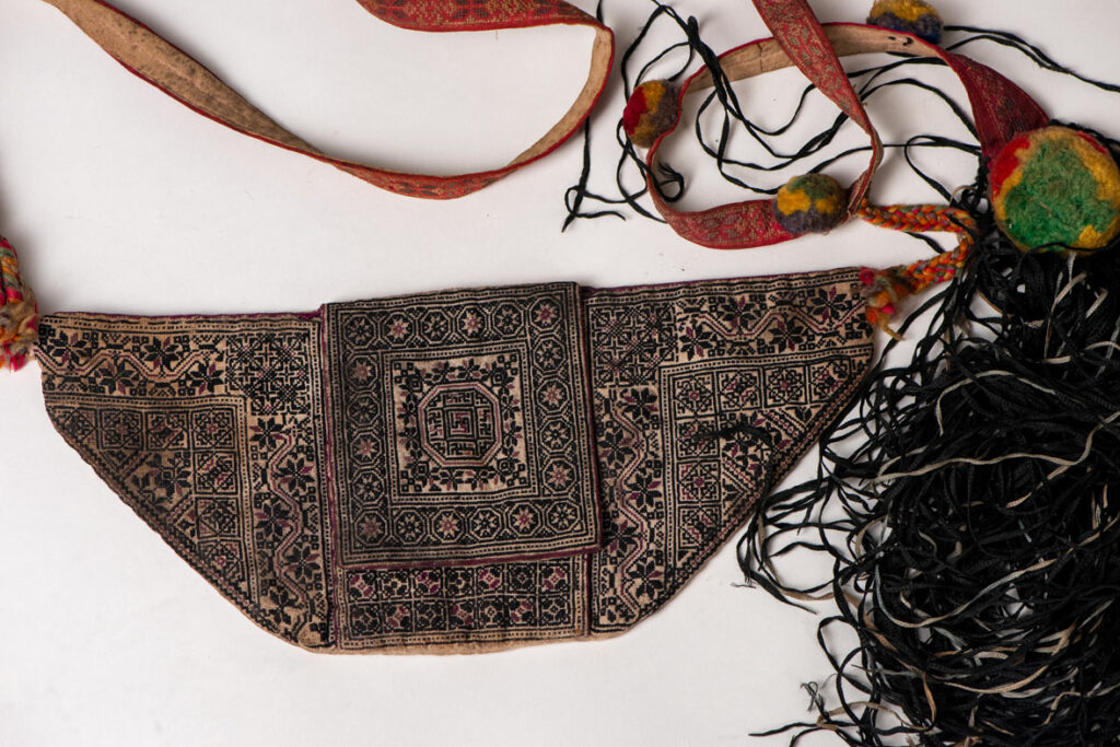 Ceremonial betel nut bag from the ami tribe, fully embroidered with distinctive motifs and inverted trapezoid shape.