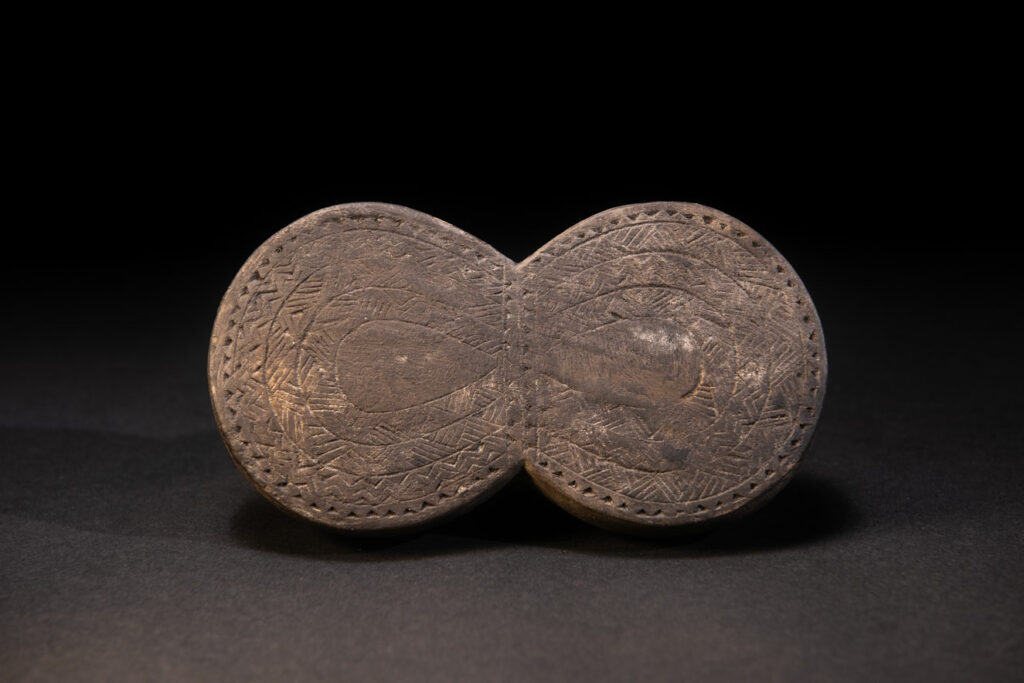 Carved wooden box from the Yami tribe containing a men’s silver necklace called obai.