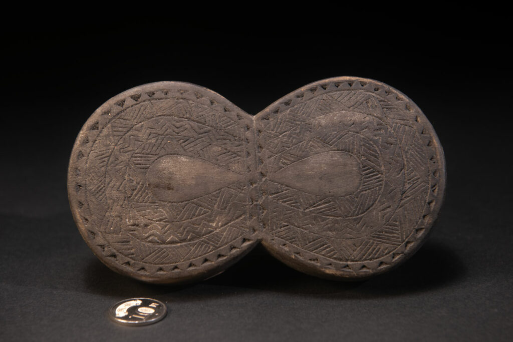 Carved wooden box from the Yami tribe containing a men’s silver necklace called obai.