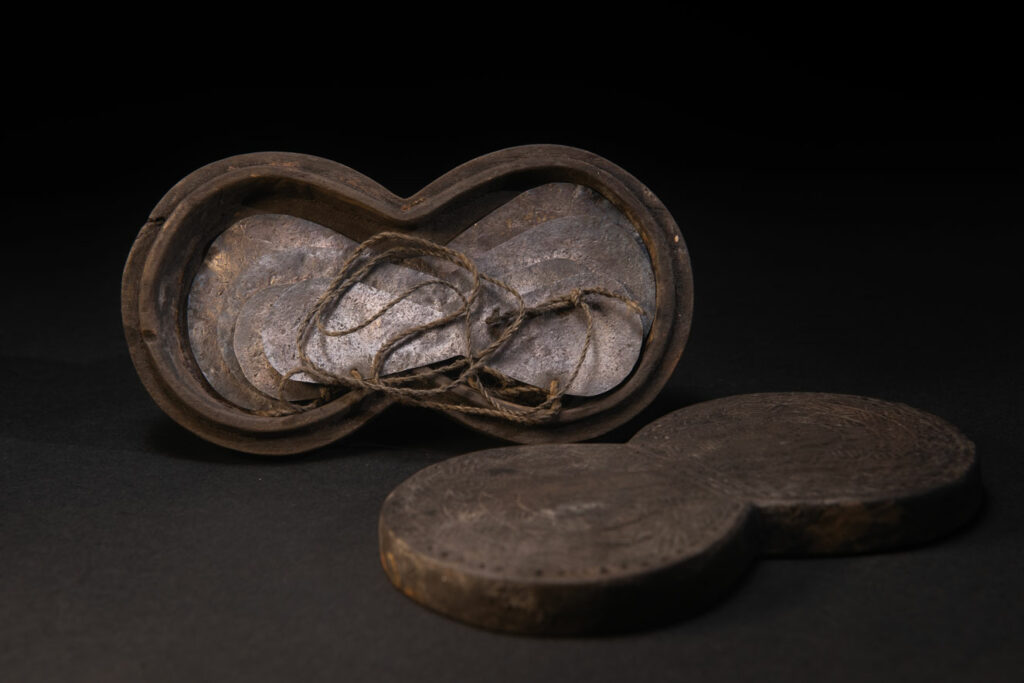 Carved wooden box from the Yami tribe containing a men’s silver necklace called obai.