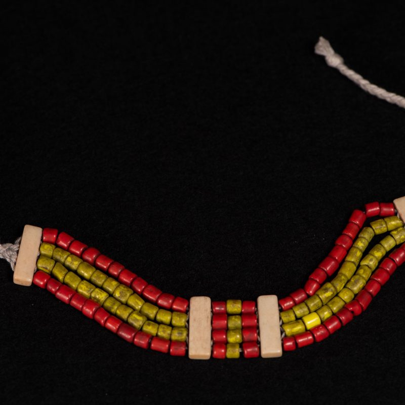 Bracelet from the Atayal tribe, made of yellow and red beads separated by polished bone bars, strung on a cord.
