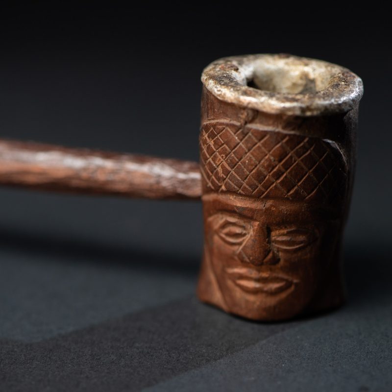 Very fine pipe from the Paiwan tribe, carved on both sides with human faces representing Paiwan warriors. The interior of the bowl is lined with aluminum.