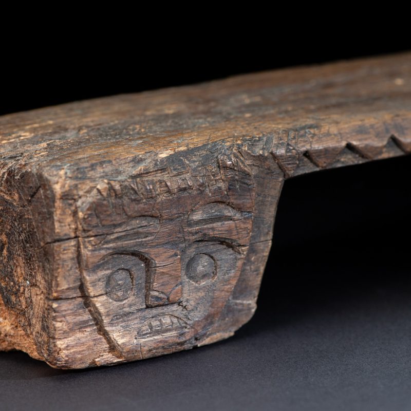 Paiwan tribe headrest in wood carved with human head pattern and deer on both side which represent abundant harvest and performance of ability.