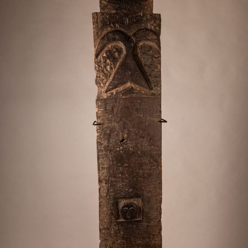 Rare and massive early 19th-century panel from the East Coast Paiwan tribe, carved in the Taimali style. It features a prominent central nose, a stylized face at the top, and another face carved at the bottom — a characteristic design of the Southeastern Paiwan tradition.