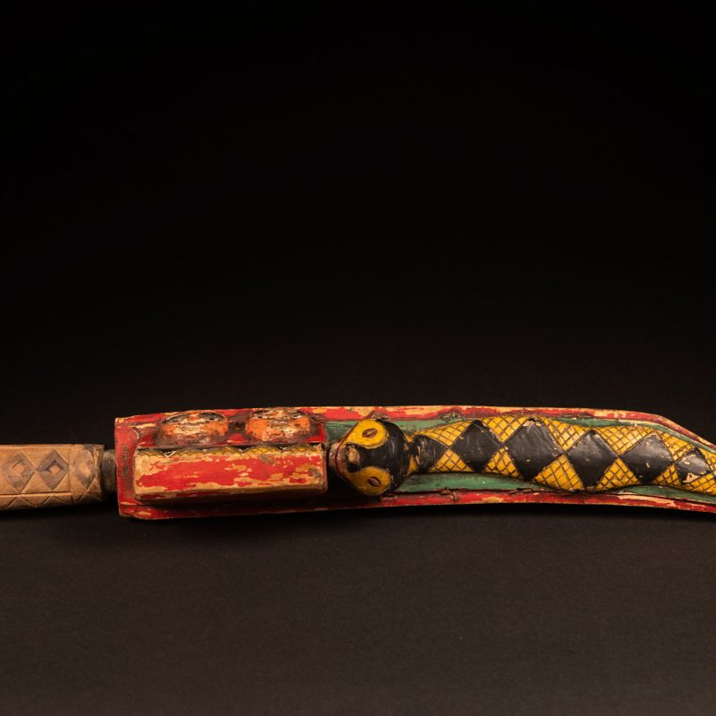 Paiwan tribe sword painted and carved with snake and human face .