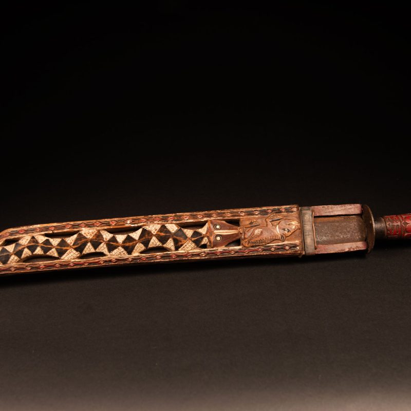 This ceremonial Paiwan sword is carved with a wild boar and a snake running along the entire length of the wooden scabbard.