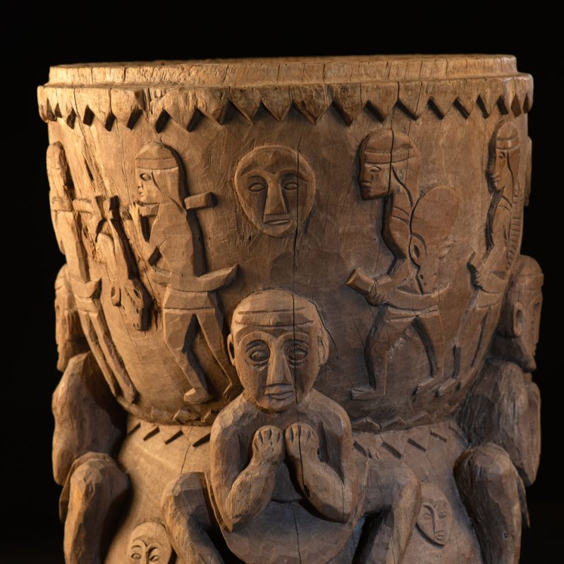 Ancient mortar from the Troukou (Pingpu) tribe, carved with crouching figures, human heads, and hunters carrying game or hunting with bows.