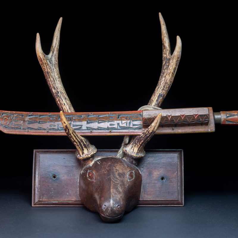 Paiwan tribe sword with a sheath carved with several standing figure and painted in red.