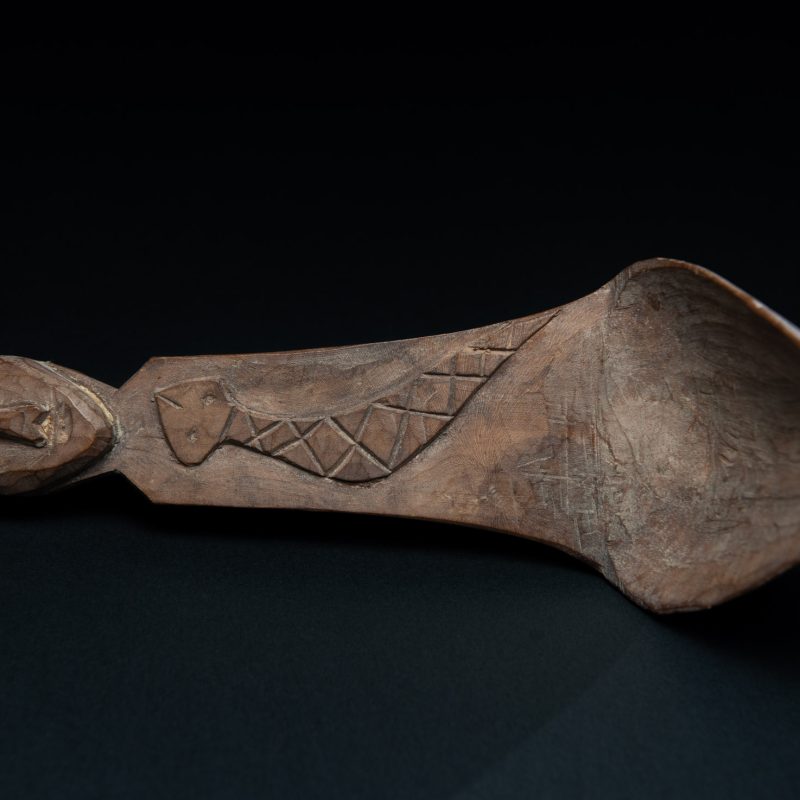Old wooden spoon from the Paiwan tribe, carved with a one hundred pace snake at the back and one human head and sacred snake at the front.