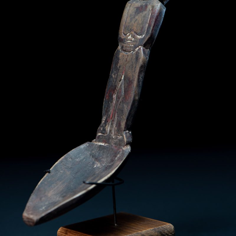 Paiwan tribe ancient wood spoon carved with a standing picture of warrior with a two-headed snake encircling the head of the upper figure. Some red tint remains.